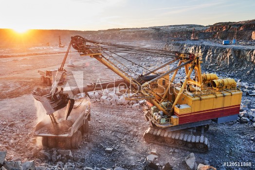 Picture of Mining excavator loading granite or ore into dump truck